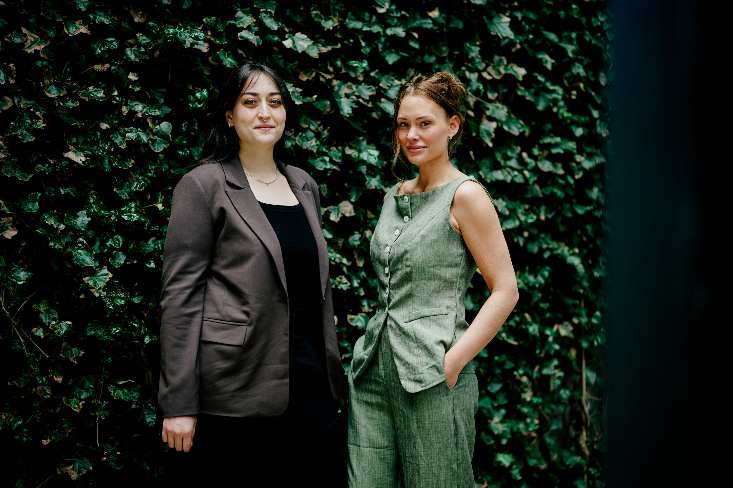 Aldras grundlæggere Josefine og Elif foran en grøn vægbeklædning